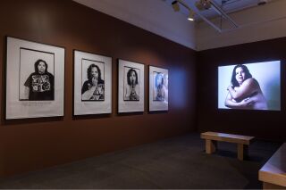 Photo of two gallery walls with four black and white photographs and projected video