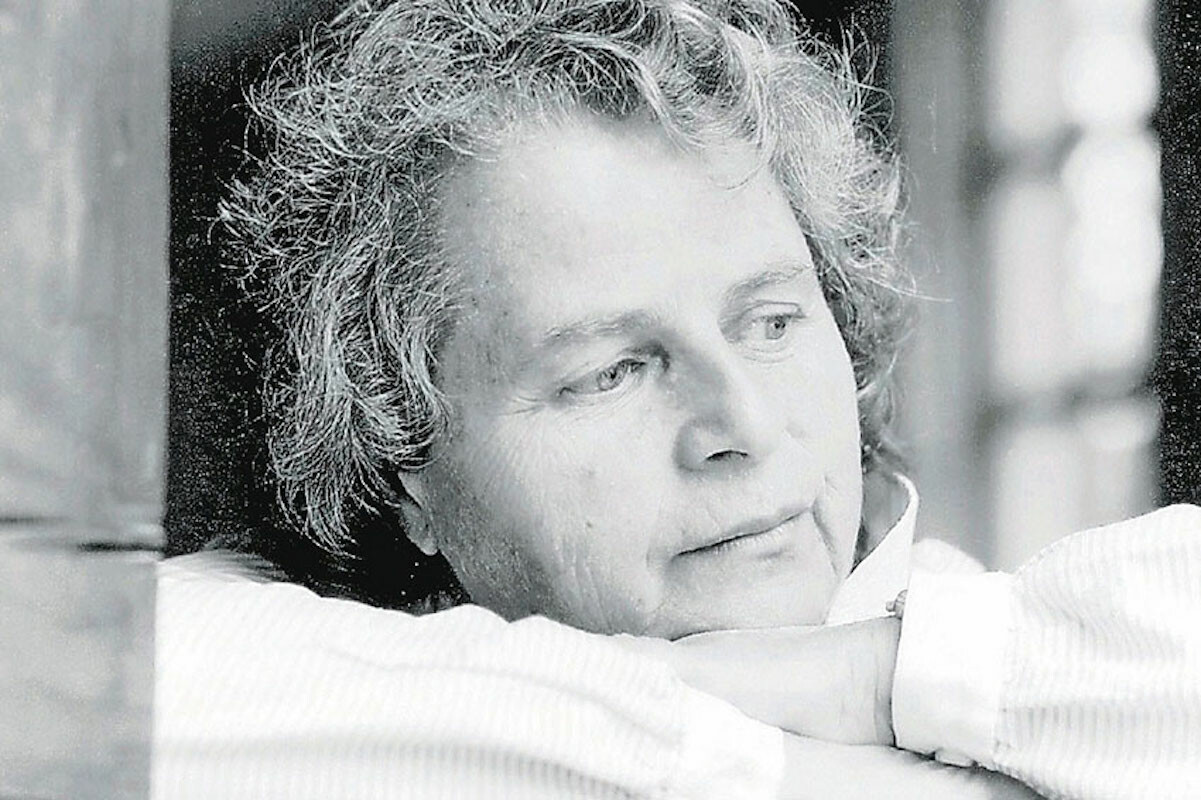 A woman leans her face on her crossed arms