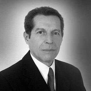A man in a suit poses for a photo in black and white