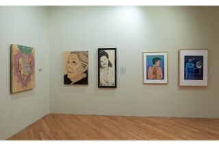 Image of two exhibit walls. Left wall shows one piece of art hanging and the right wall shows four pieces of art
