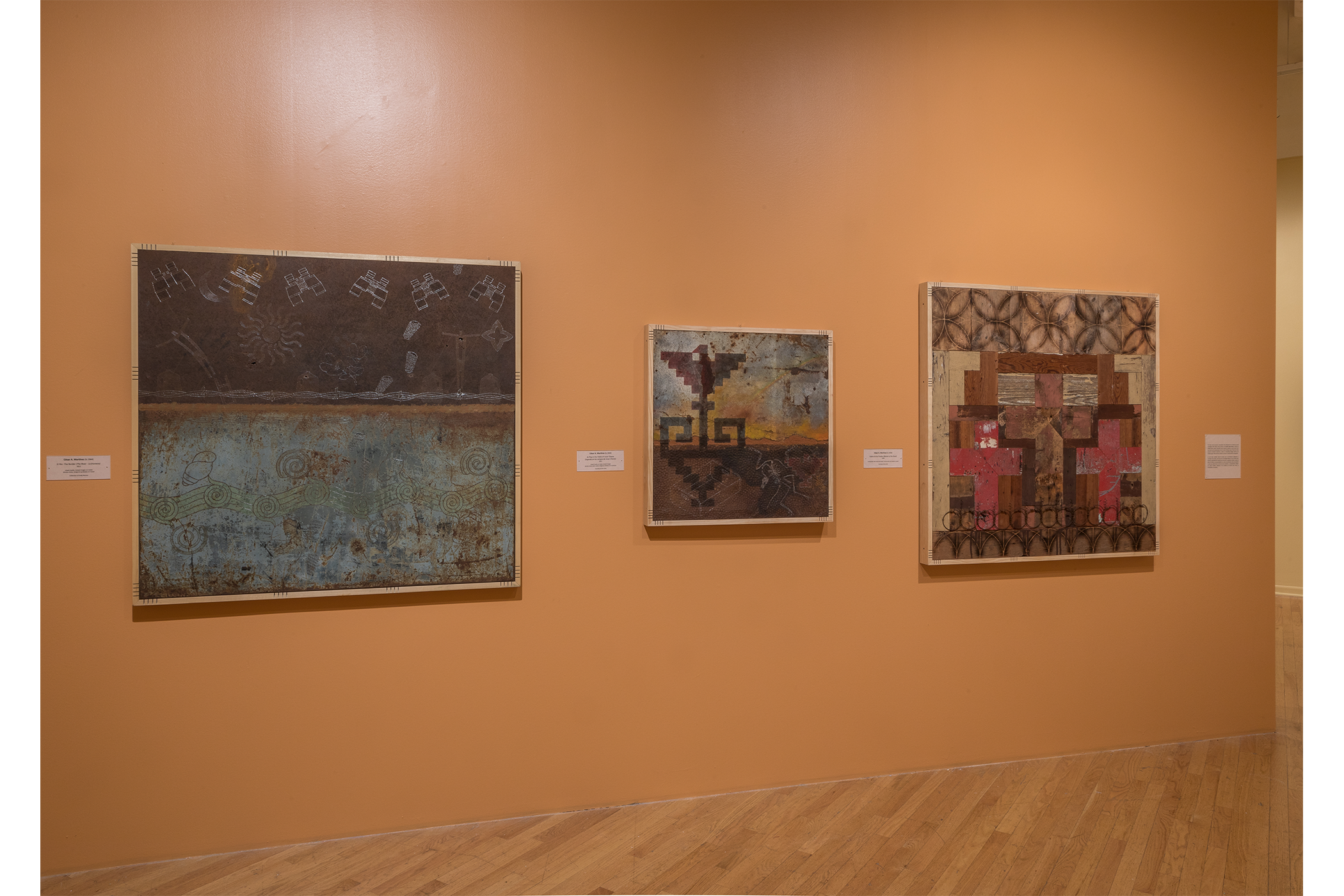 Three artworks hanging on the wall.