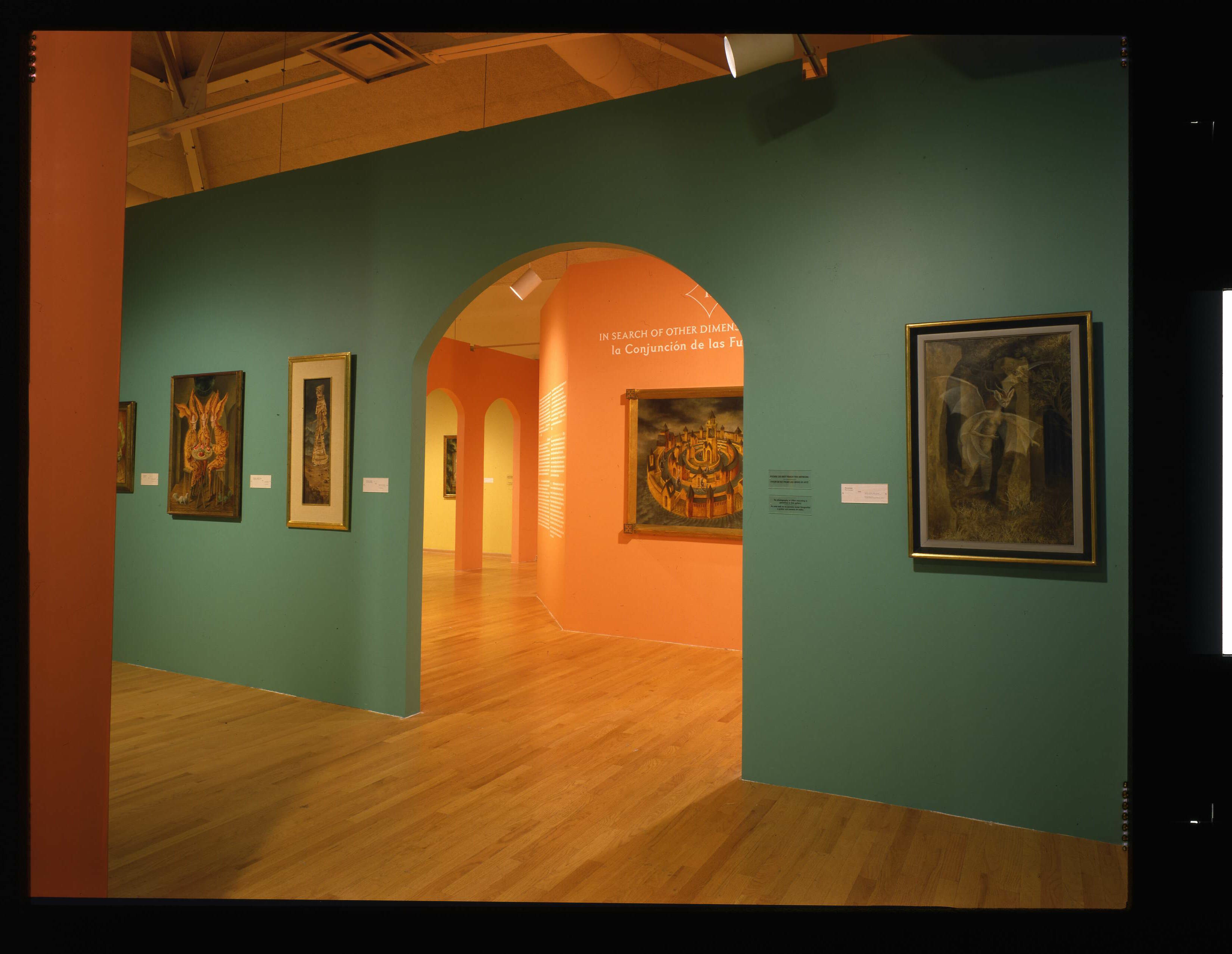 Image of gallery. Teal and orange walls visible with Remedios Varo's artwork hanging
