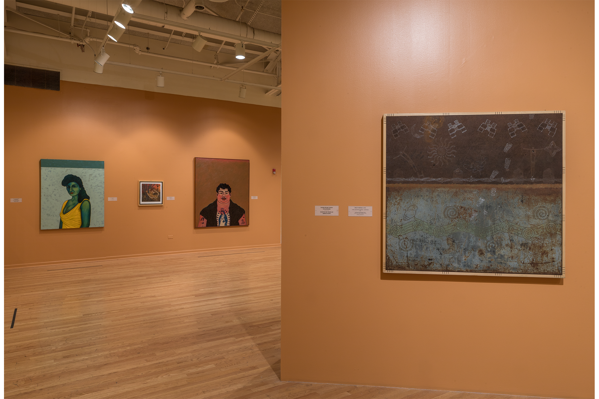 Background, three pieces of art hang on the wall. Foreground on the right, the El Rio art piece.