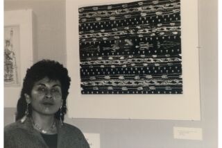 Black and white photograph of artist in front of her screen print