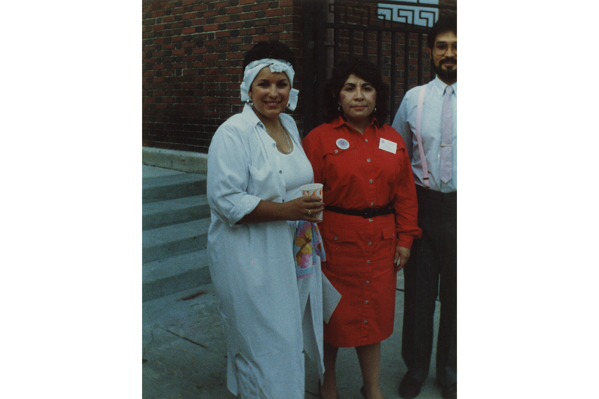 Color photograph of two women and a man outside of museum