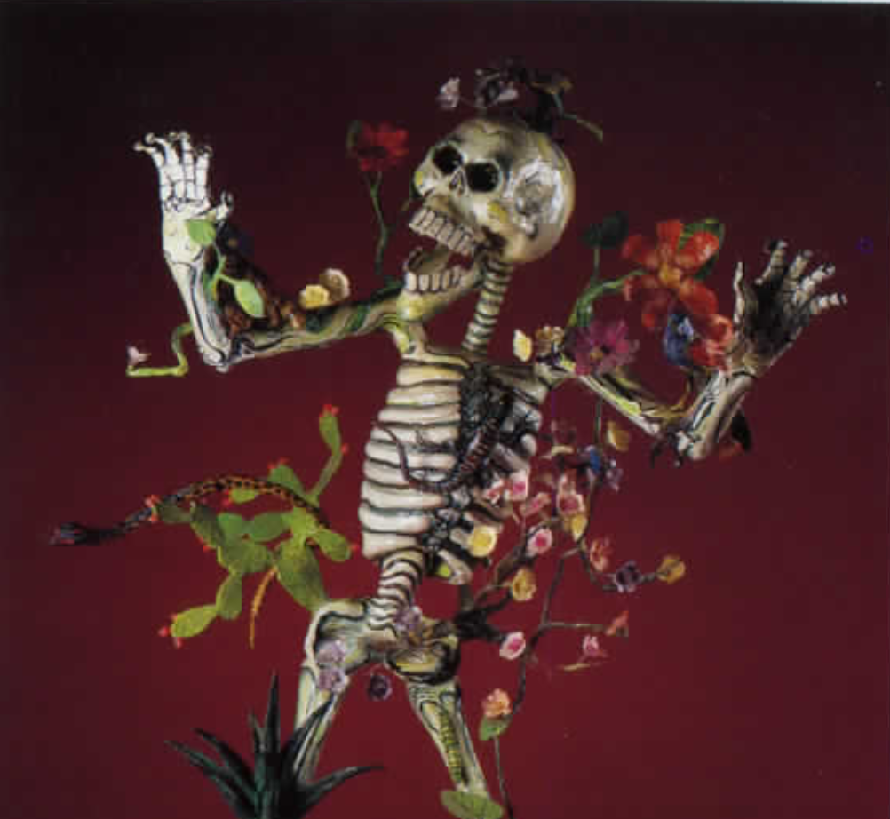 Skeleton with arms outstretched and plants and animals growing from its bones