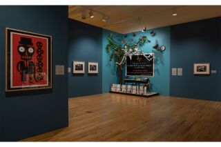 Gallery exhibits on display in a blue and turquoise room.