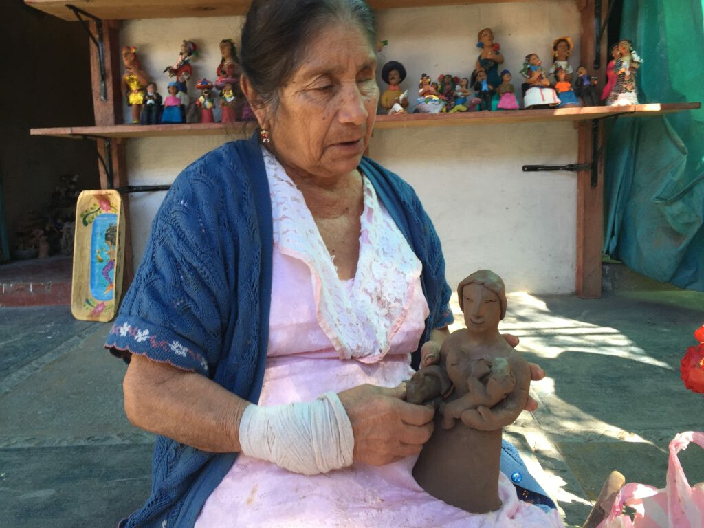 Photo of a Jofefina Aguilar holding a clay sculpture