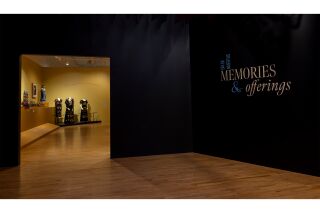 The title of the exhibition on the black wall, “Dia de Muertos: Memories and offerings.”