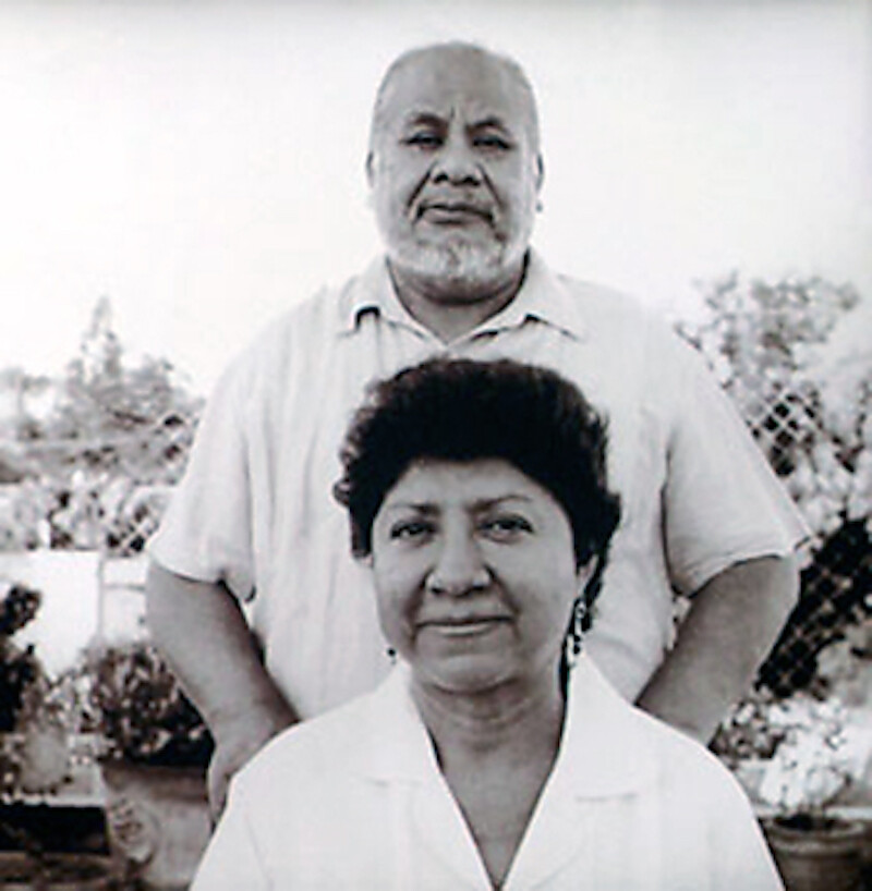 A man stands behind a seated woman for a photograph