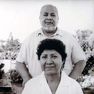 A man stands behind a seated woman for a photograph