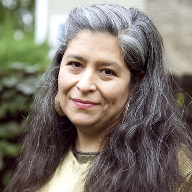 A woman with long black hair poses for a photo