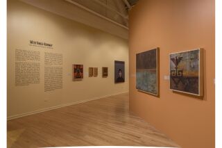 The introduction text alongside five hanging pieces of art. Two hanging art pieces on the wall to the right.
