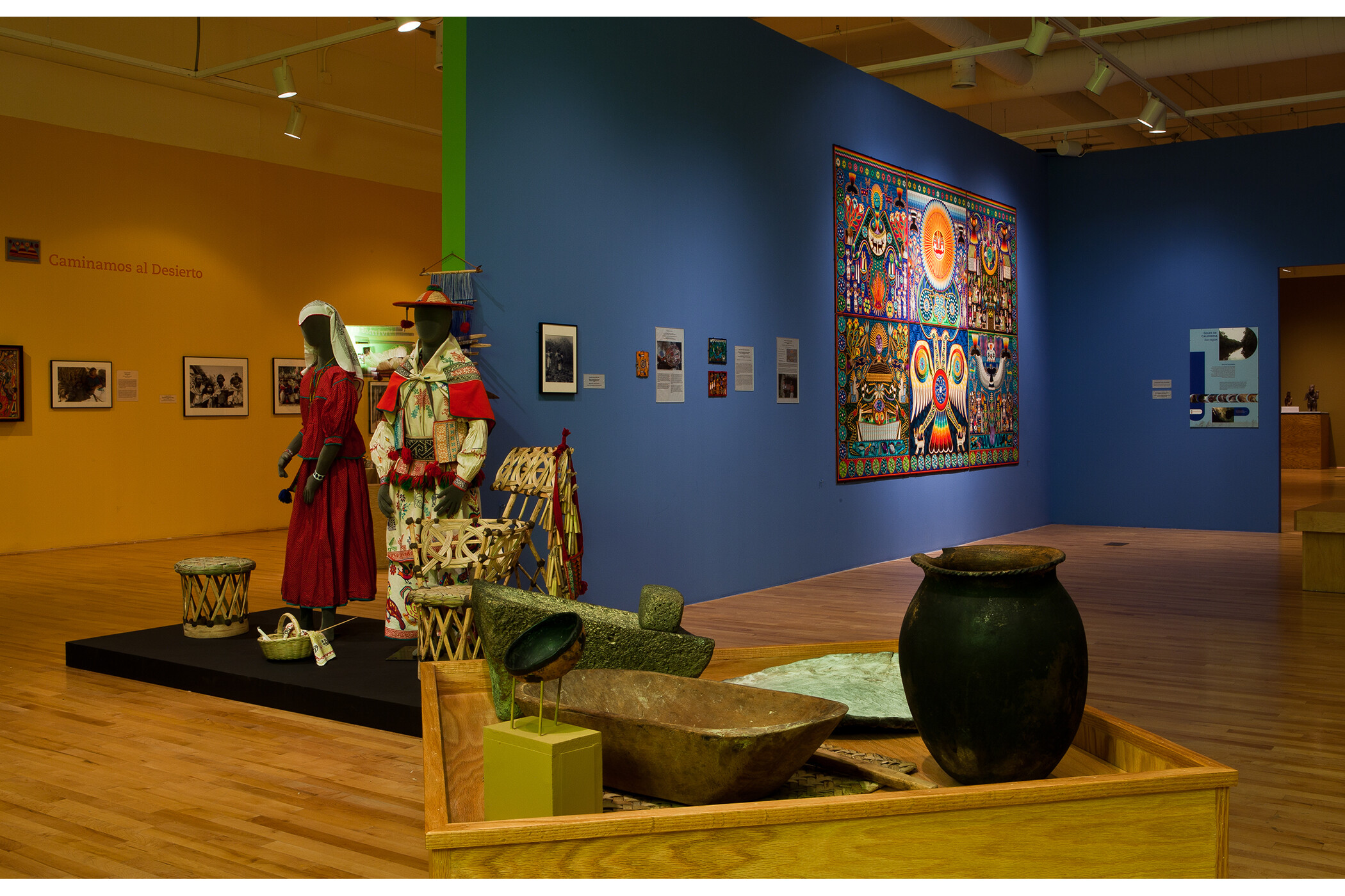 Photo of multiple gallery walls, with focus on 3-dimensional artifacts in center of room