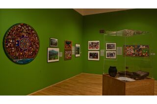 Gallery photo including photographs, works on paper, painting, and 3-D artifacts
