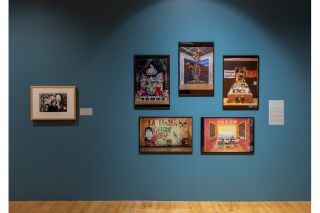 Framed photographs hang on the wall, one is Reyes Rodriguez’s piece Maricela, the other is a collection of 5 photographed Ofrendas from past museum exhibitions.