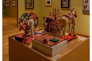 close up view of the polychrome wood and papier-mâché art pieces from previous image.