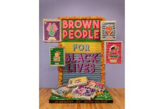 A large paper maché installation that reads: Brown People for Black Lives.