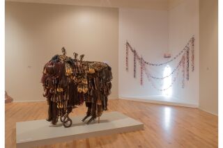 two art pieces displayed; a buffalo made out of bunches of hair, a installation of chains made out of tape and photography depicting. content warning: gore. mutilated bodies due to the cartel.