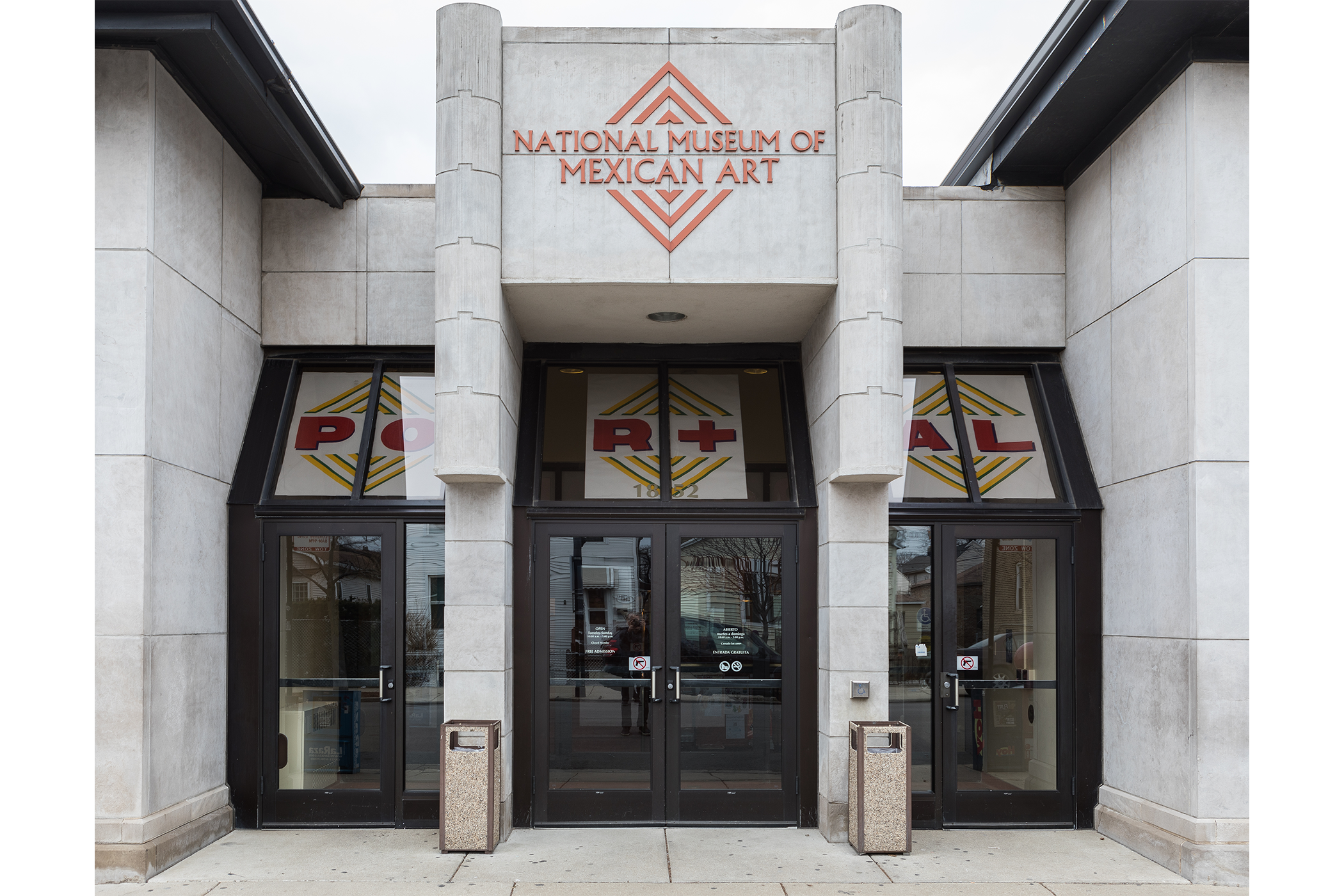 shot of the front of the museum; the art pieces sit at the top of the entrances and is seeable through the glass.