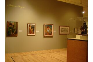 One gallery wall with five paintings visible and one sculpture encased in glass in center of room