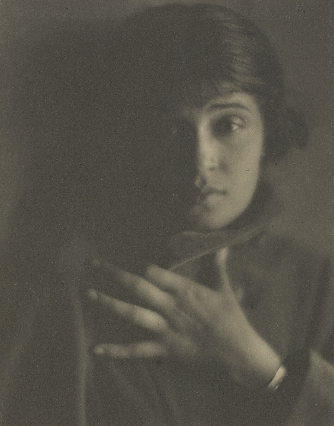 A woman holds her palm to her chest