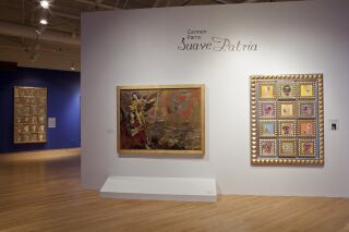 exhibiton title wall with two art pieces hanging, with one in the background to the left of the wall.