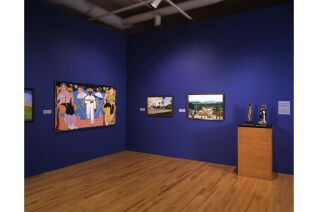 Two walls displaying three paintings visible. On the right is a podium against the wall displaying two small sculptures