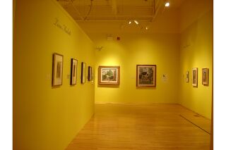 Gallery view shows three walls but focuses on back wall with two paintings and artist description