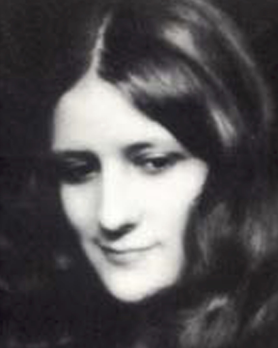 A woman with long hair looks away from the spectator