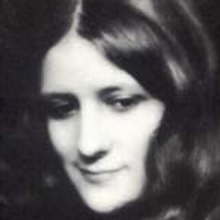 A woman with long hair looks away from the spectator